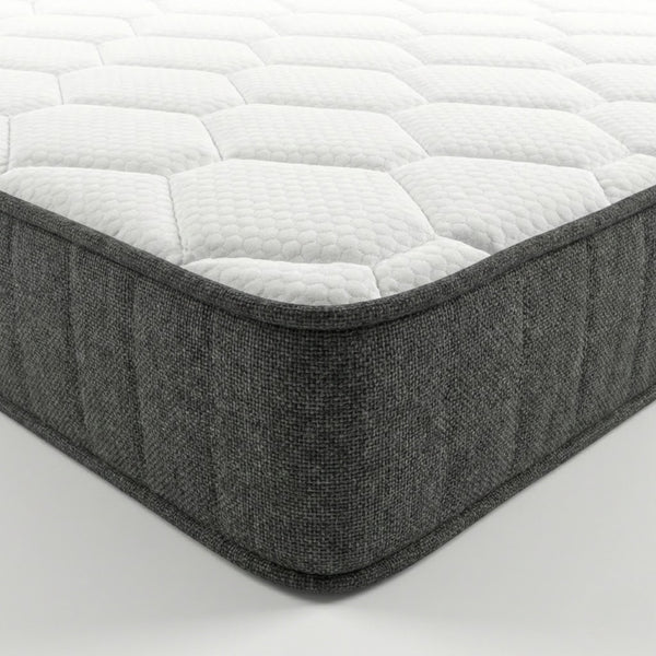 Vista lateral del colchón ESSENTIAL Pro mostrando su grosor de 21 o 25 cm con cara superior acolchada y base en tejido gris.